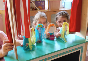 dziewczynki inscenizują przedstawienie z wykorzystaniem kukiełek