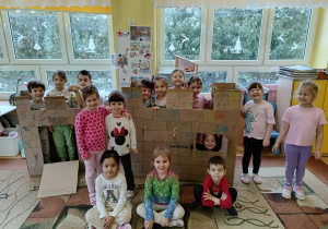 dziewczynki pozują do zdjęcia z kartonowym zamkiem