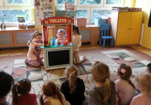 dziewczynki inscenizują przedstawienie z wykorzystaniem kukiełek