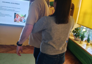 Rodzice ćwiczą pozycję w trakcie ratowania w przypadku zakrztuszenia lub zadławienia.