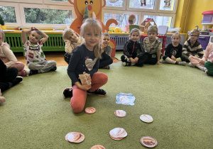 Dzieci rozwiązują zadania matematyczne na dywanie