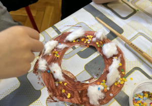 dzieci przy stolikach wykonują pracę plastyczne