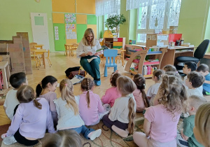 dzieci siedzą na dywanie - słuchają zagadek