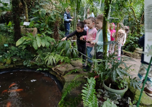 dzieci spacerują po palmiarni, oglądają ryby