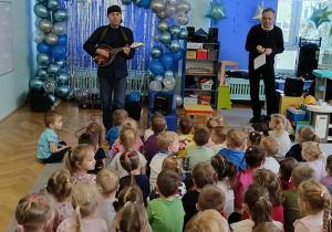 dzieci siedzą w sali słuchając koncertu