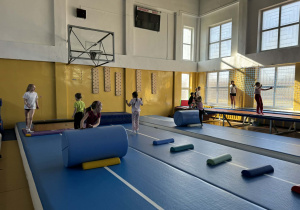 Dzieci ćwiczą na sali gimnastycznej