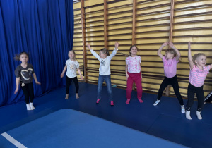 Dzieci ćwiczą na sali gimnastycznej