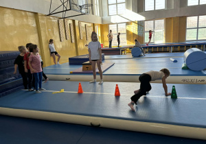 przedszkolaki pokonują tor przeszkód podczas zajęć sportowych.