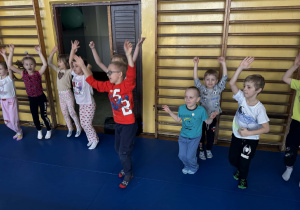 Dzieci ćwiczą na sali gimnastycznej