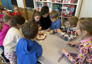 Dzieci przy stolikach wykonują pracę plastyczne