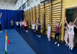 Dzieci ćwiczą na sali gimnastycznej