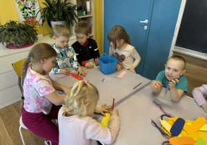 Dzieci przy stolikach wykonują pracę plastyczne