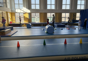 przedszkolaki pokonują tor przeszkód podczas zajęć sportowych.