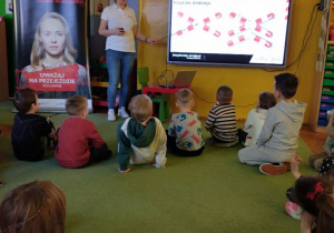 Dzieci siedzą na dywanie