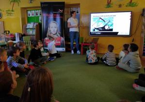 Dzieci siedzą na dywanie