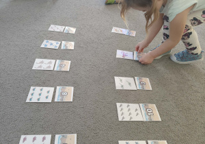 Dzieci siedzą w kole, uczestniczą w zabawie matematycznej: "Ile dinozaurów?".