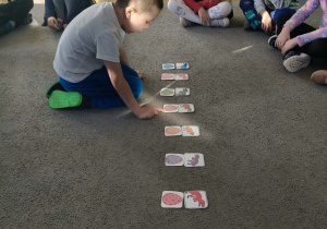 Dzieci siedzą w kole, zabawa "Z jakiego koloru jajka wykluł się dinozaur?"