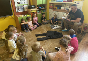 tata Tymka czyta dzieciom książkę