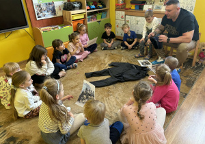 tata Tymka opowiada dzieciom o swojej pracy i pokazuje rekwizyty związane z jego pracą