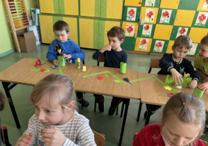 Dzieci siedzą w ławkach