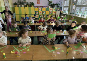 Dzieci siedzą w ławkach