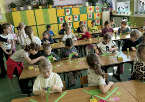 Dzieci siedzą w ławkach