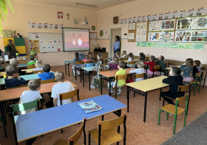 Dzieci siedzą w ławkach