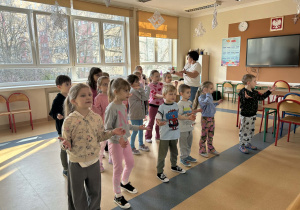 dzieci uczestniczą w lekcji muzyki i śpiewają piosenkę „Żabka mała”