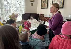 dzieci zwiedzają pomieszczenia mieszkalne w dawnych czasach