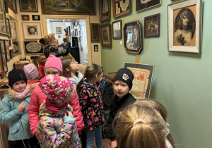 dzieci zwiedzają pomieszczenia mieszkalne w dawnych czasach