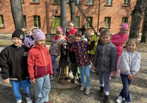 dzieci pozują do zdjęcia przy zabytkowej studni na Księżym Młynie