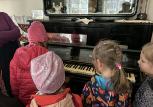 dzieci zwiedzają pomieszczenia mieszkalne w dawnych czasach