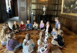 dzieci siedzą w muzeum i słuchają ciekawostek na temat życia w dawnych czasach,