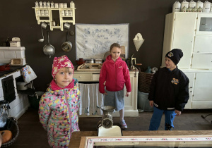 dzieci zwiedzają pomieszczenia mieszkalne w dawnych czasach