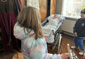 dzieci zwiedzają pomieszczenia mieszkalne w dawnych czasach