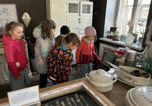 dzieci zwiedzają pomieszczenia mieszkalne w dawnych czasach