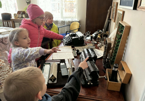 dzieci zwiedzają pomieszczenia mieszkalne w dawnych czasach