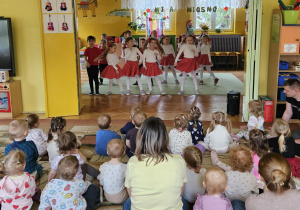 dzieci z grupy srebrnej tańczą, na widowni maluchy oglądają występ