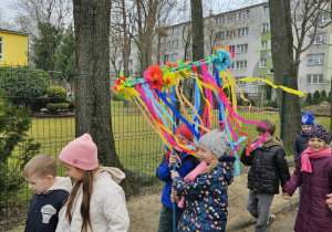 dzieci spacerują w okolicy naszego przedszkola, śpiewają piosenki o wiośnie