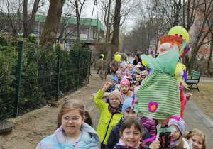 dzieci spacerują w okolicy naszego przedszkola, śpiewają piosenki o wiośnie