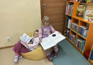 dzieci oglądają książki w bibliotece