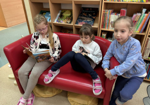 dzieci oglądają książki w bibliotece