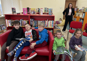 dzieci oglądają książki w bibliotece