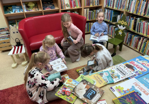 dzieci oglądają książki w bibliotece