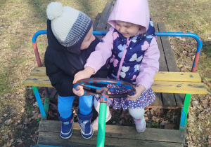 Dziewczynka i chłopiec naśladują jazdę samochodem