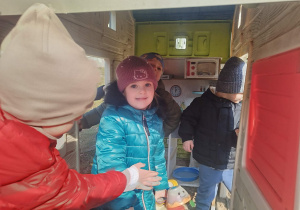 Dzieci bawią się w ogrodowym domku