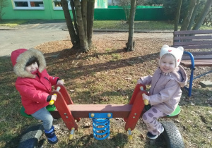 Dzieci bujaja się na huśtawce "koniki"