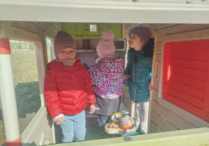 Dzieci bawią się w ogrodowym domku