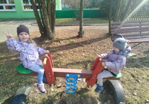 Dzieci bujaja się na huśtawce "koniki"