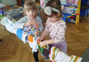 Dzieci wieszają pranie na sznurku, używając klamerek